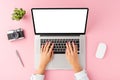 WomanÃ¢â¬â¢s hands working on laptop with empty screen on pink background. Office desktop with accessories. Royalty Free Stock Photo